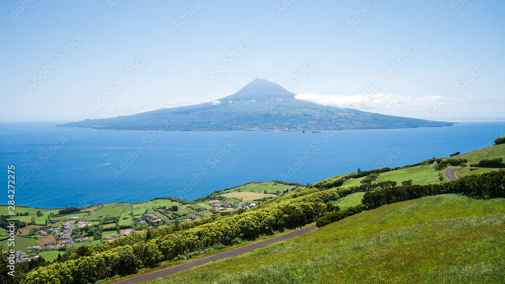The volcanic island of Pico with the famous Pico volcano and the atlantic ocean, coastline of Faial Island, Azores Islands, Portugal
