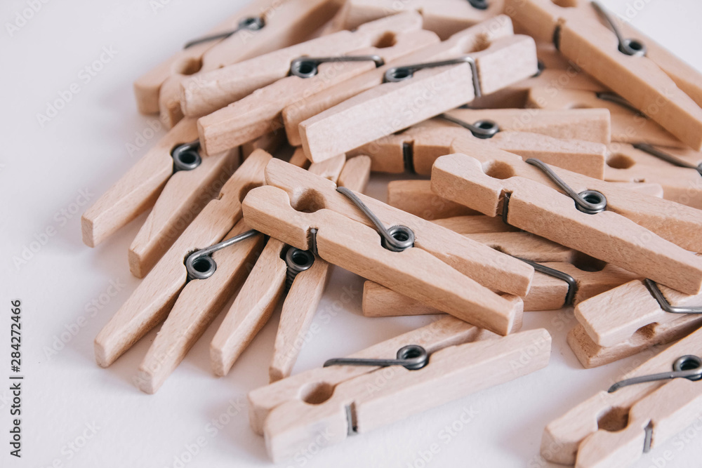 Wooden clothespins scattered on a white background. View from above. Copy space Wooden clothespins scattered on a white background. View from above. Copy space