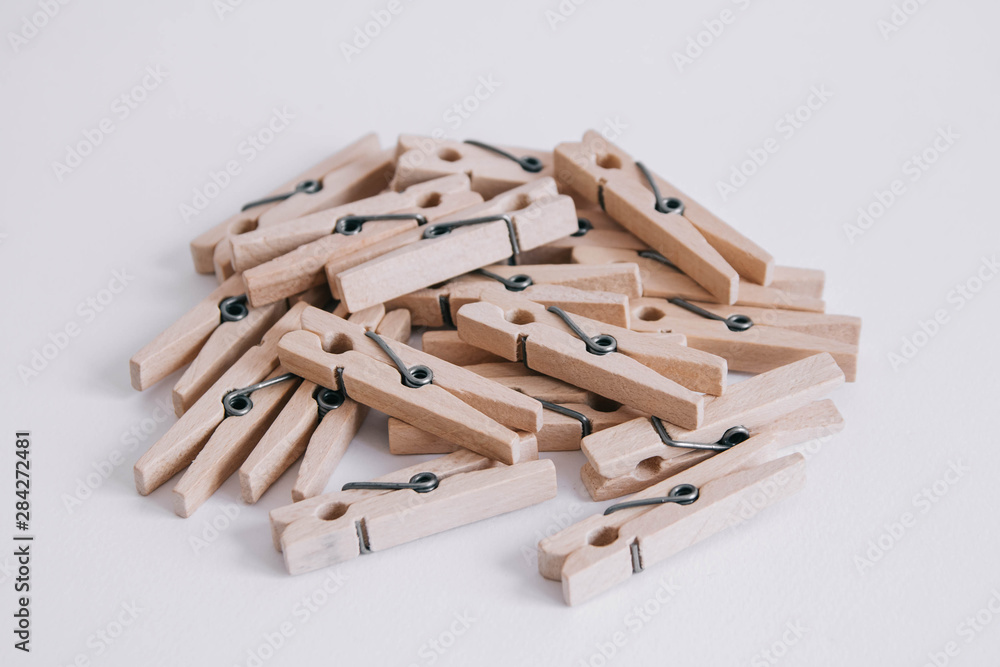Wooden clothespins scattered on a white background. Copy space