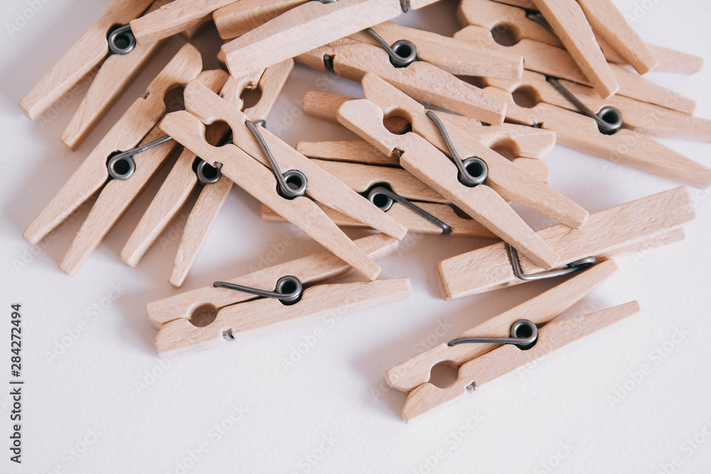 Wooden clothespins scattered on a white background. View from above. Copy space Wooden clothespins scattered on a white background. View from above. Copy space