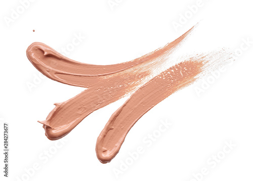 Gently beige strokes and texture of makeup foundation or acrylic paint isolated on white background