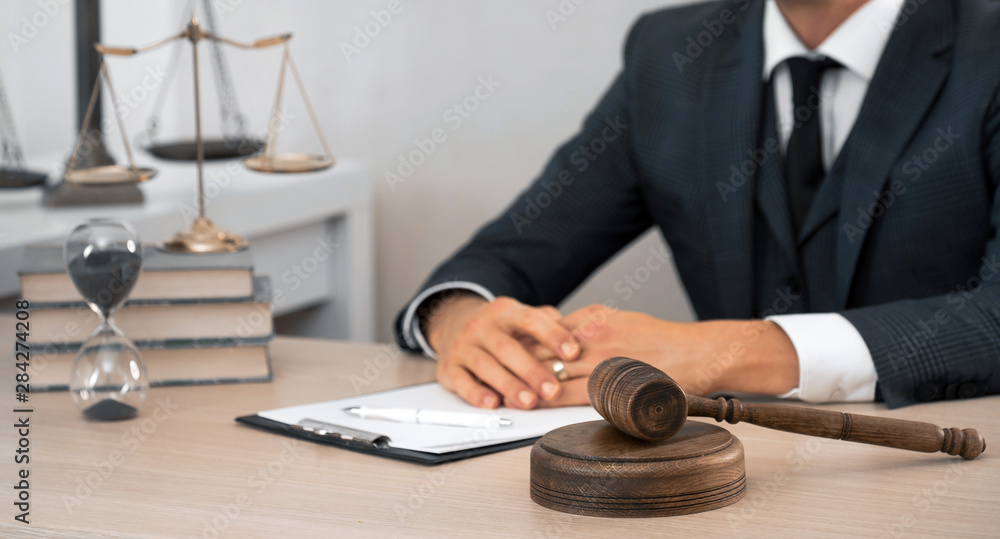Law and Legal services concept. Male lawyer or judge working with contract papers, Law books and wooden gavel on table in courtroom Law and Legal services concept. Male lawyer or judge working with contract papers, Law books and wooden gavel on table in courtroom