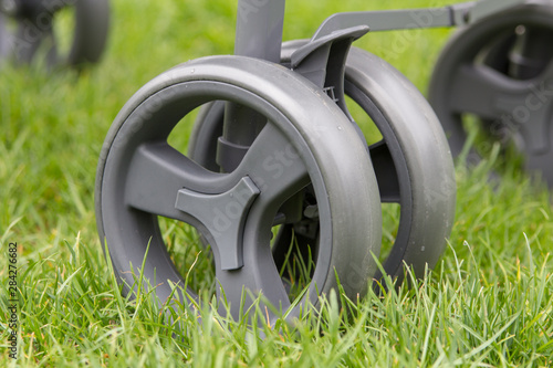 baby stroller wheel,closeup wheel of baby trolley on grass in summer