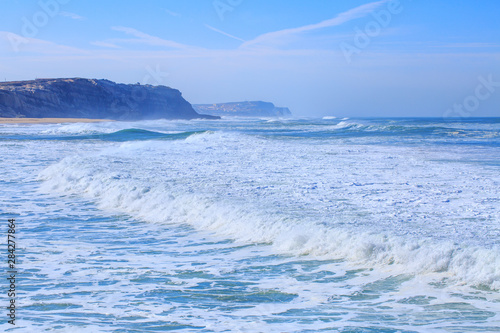 Fototapeta Naklejka Na Ścianę i Meble -  A huge waves on the ocean coast in a shine bright light  at sunny day. Wonderful romantic seascape of ocean coastline.