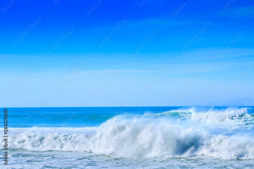 A huge waves on the ocean coast in a shine bright light  at sunny day. Wonderful romantic seascape of ocean coastline.