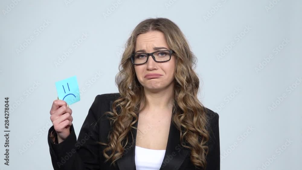 Lady holding paper stick expressing awful mood then takes another expressing good mood, slow motion Lady holding paper stick expressing awful mood then takes another expressing good mood, slow motion