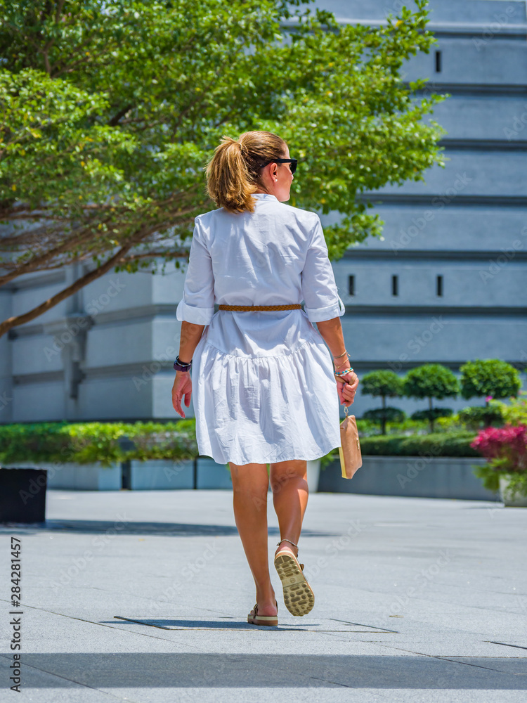 Woman walking in the marina bay area Woman walking in the marina bay area