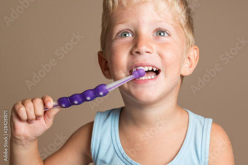 little baby boy with tooth brush,kid boy smiling happiness,dental hygiene and health for children,brown background.