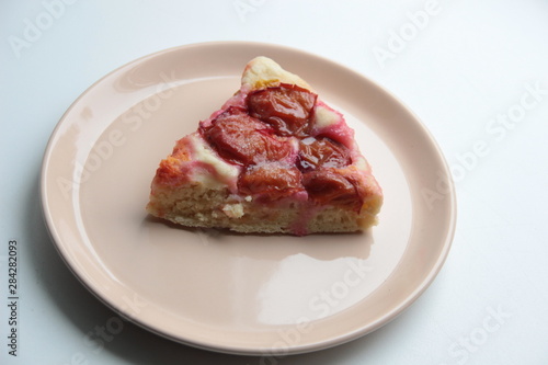 Slice of plum cake on plate with background