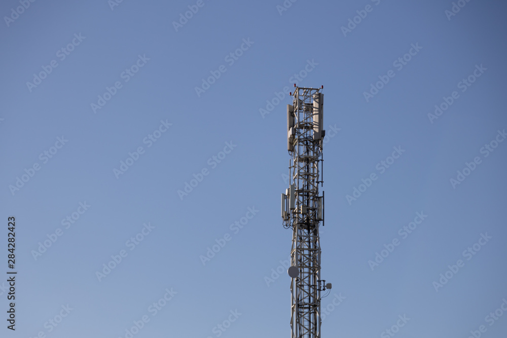 high telecommunication antenna with blue sky background