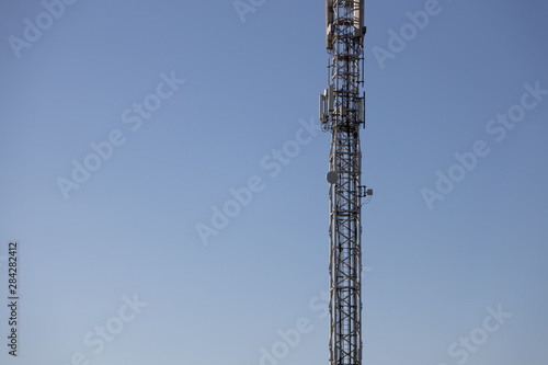 high telecommunication antenna with blue sky background