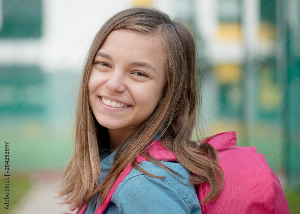 Schoolchild go to school with backpack. Cute child - teen girl with bag against the background of school. Back to school concept. Schoolchild go to school with backpack. Cute child - teen girl with bag against the background of school. Back to school concept.