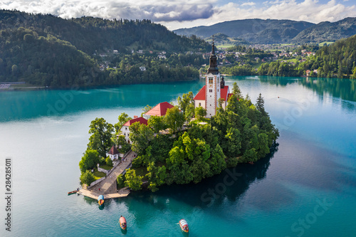 Bled, Slovenia - Beautiful morning at Lake Bled (Blejsko Jezero) with the Pilgrimage Church of the Assumption of Maria and traditional Pletna boats on the water on a bright summer day