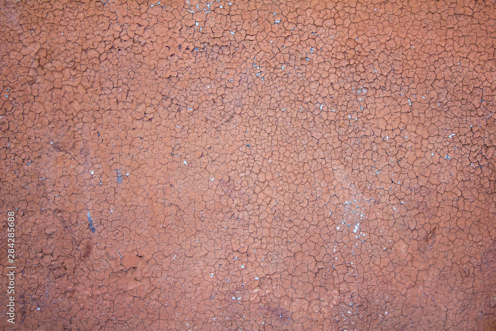 old concrete wall with cracks and peeling pink red paint. rough surface texture old concrete wall with cracks and peeling pink red paint. rough surface texture