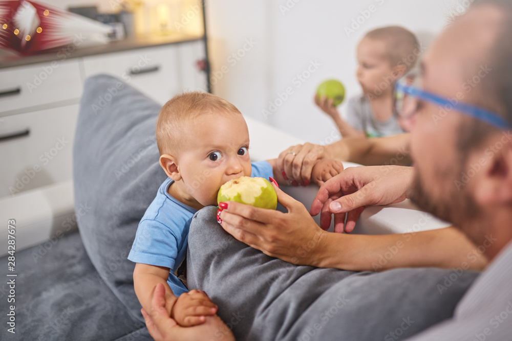 Parents feeding their baby with healthy green apple. Parents feeding their baby with healthy green apple.
