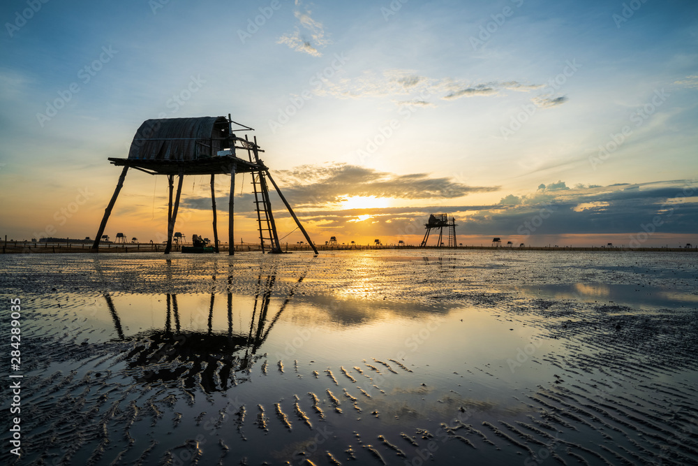 Sunrise on oyster raising field with watchtowers in Dong Chau beach, Thai Binh, Vietnam Sunrise on oyster raising field with watchtowers in Dong Chau beach, Thai Binh, Vietnam