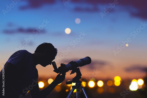 Fototapeta Astronomer with a telescope watching at the stars and Moon