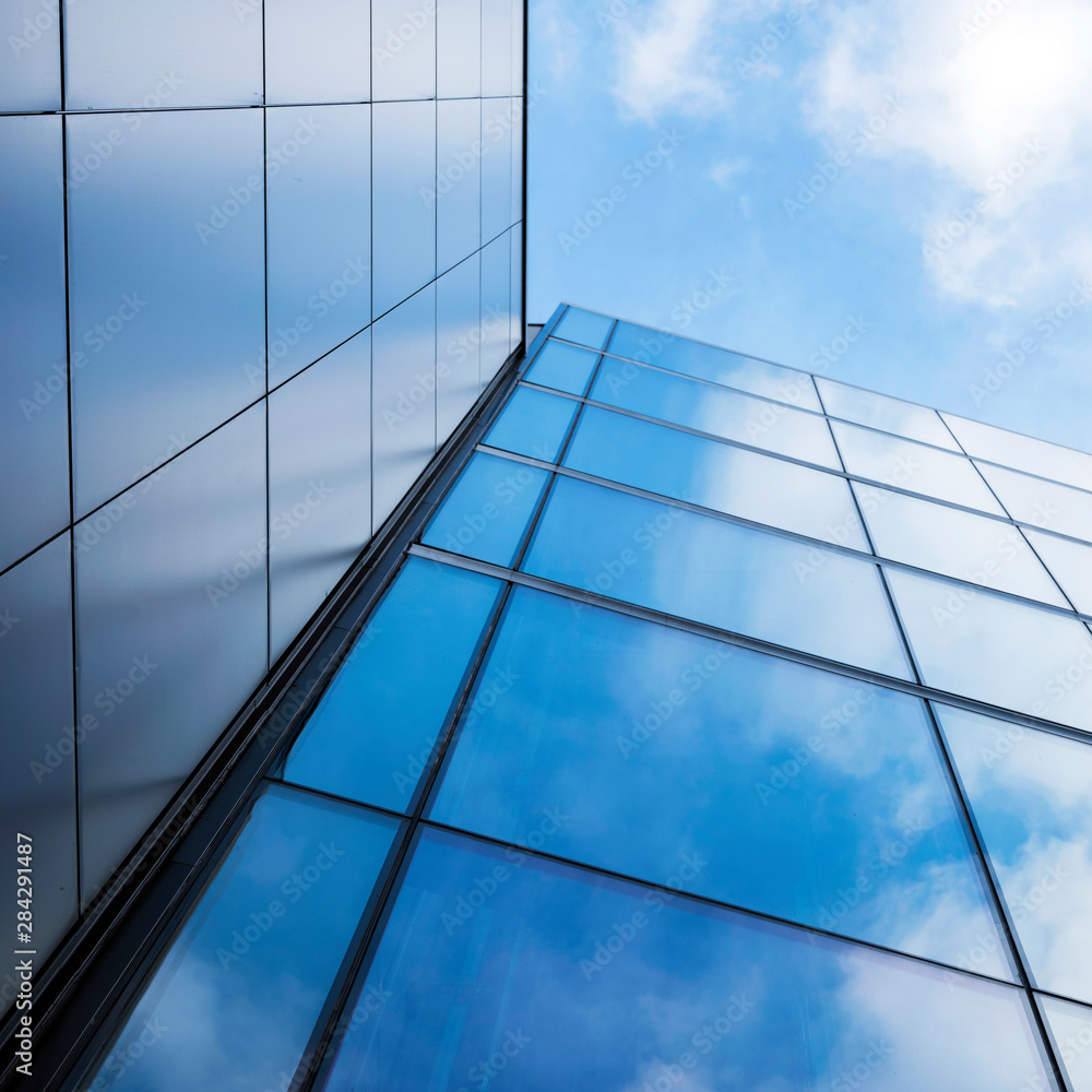 detail of modern office building with glass and steel reflecting blue sky detail of modern office building with glass and steel reflecting blue sky