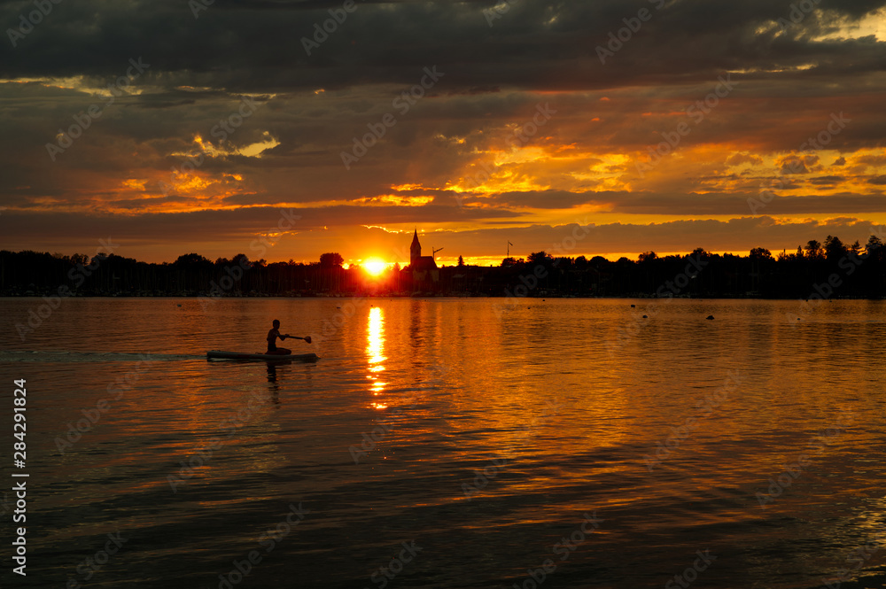 Naklejka premium Paddeln auf dem Chiemsee im Sonnenuntergang