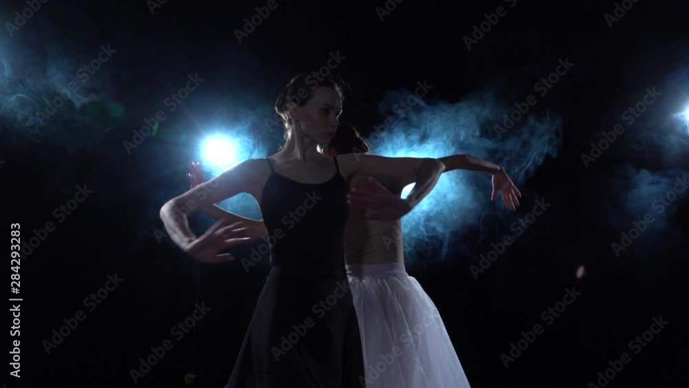 Tender ballerinas in white and black tutu spinning in dance. Close up, slow motion. Tender ballerinas in white and black tutu spinning in dance. Close up, slow motion.