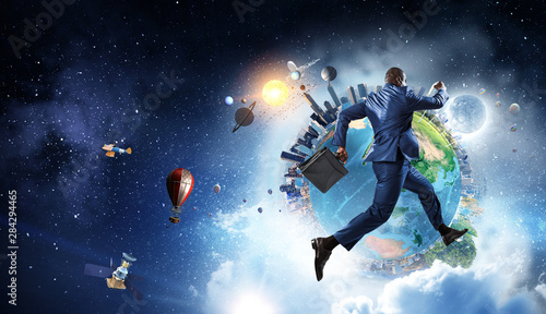Black businessman running near Earth planet with city skyline on sky and space background