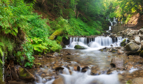 Landscape of waterfall Shypit in the Ukrainian Carpathian Mountains on the long exposure. Landscape panorama. Noises and large grain - stylization under the film. Soft focus
