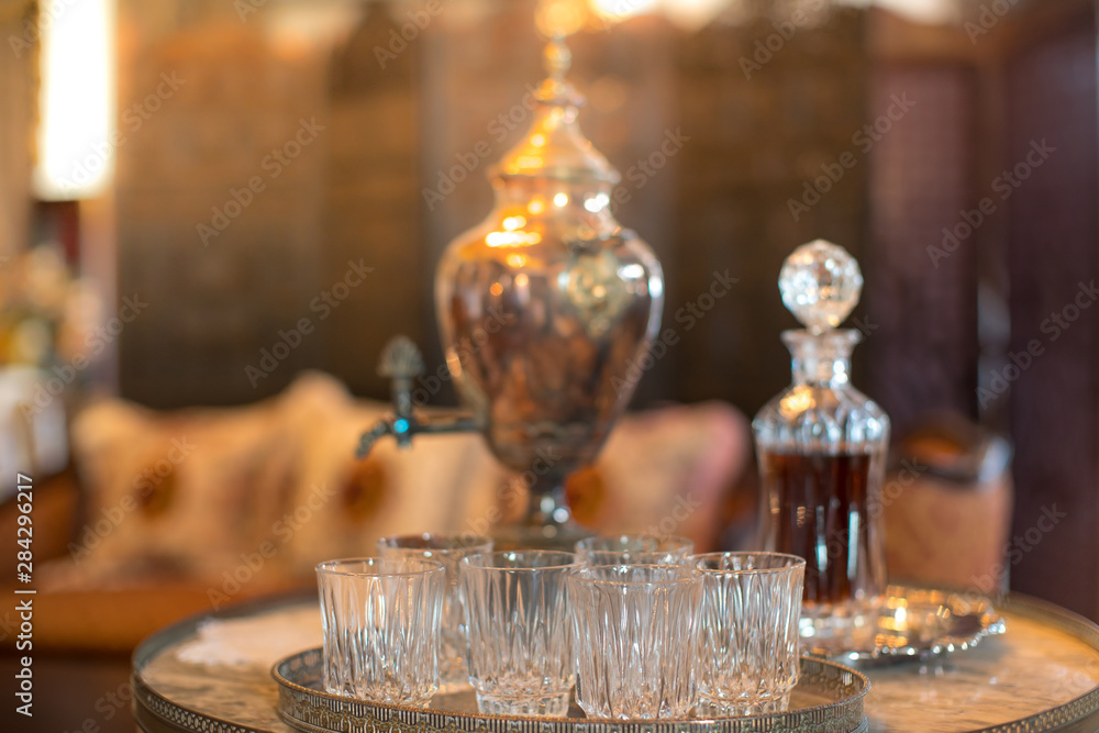 empty whiskey glass is placed on the table in an elegantly decorated room.Whiskey Crystal Bottle Placed on the table.soft focus.