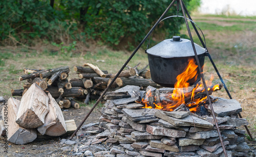 Cooking in a pot on a campfire.
