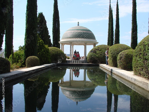 templete con cipreses reflejados en estanque jardin botanico la concepcion malaga photo