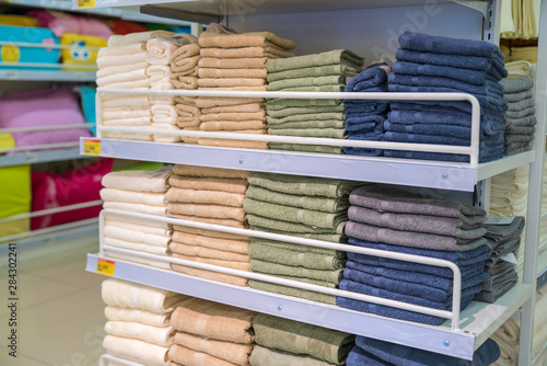 Stacks of colored towels on the shelves in supermarket