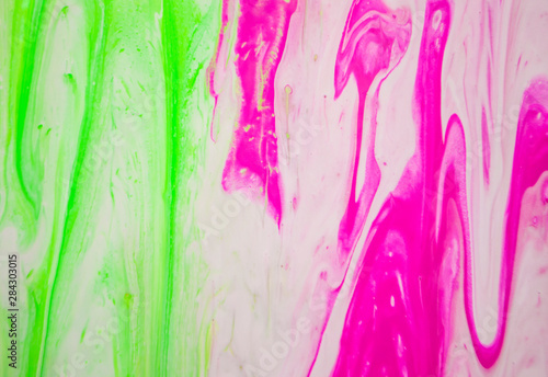 Abstract colorful painting background made in fluid art technique. Trendy pattern in green and pink colors.