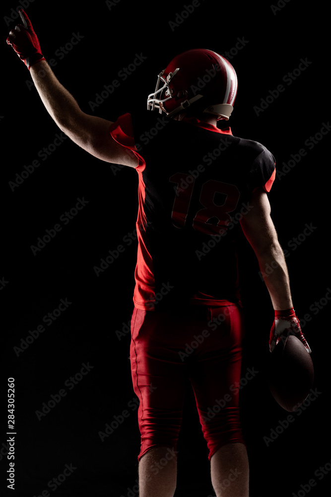 American football player in helmet pointing upwards