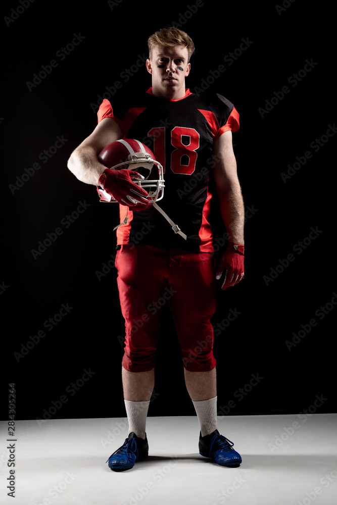 American football player holding rugby helmet American football player holding rugby helmet
