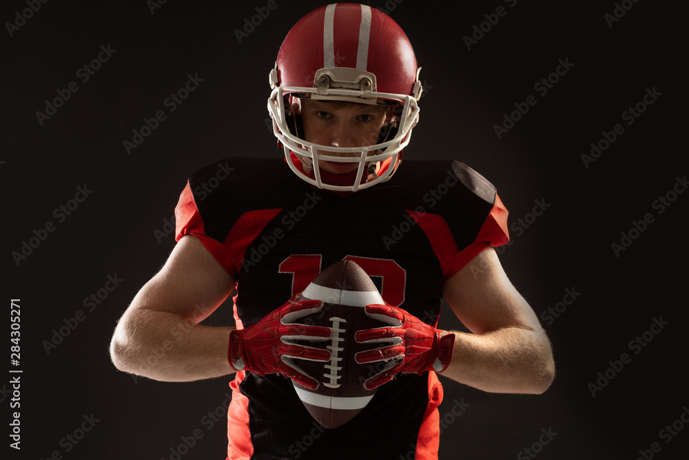 American football player in helmet holding rugby ball
