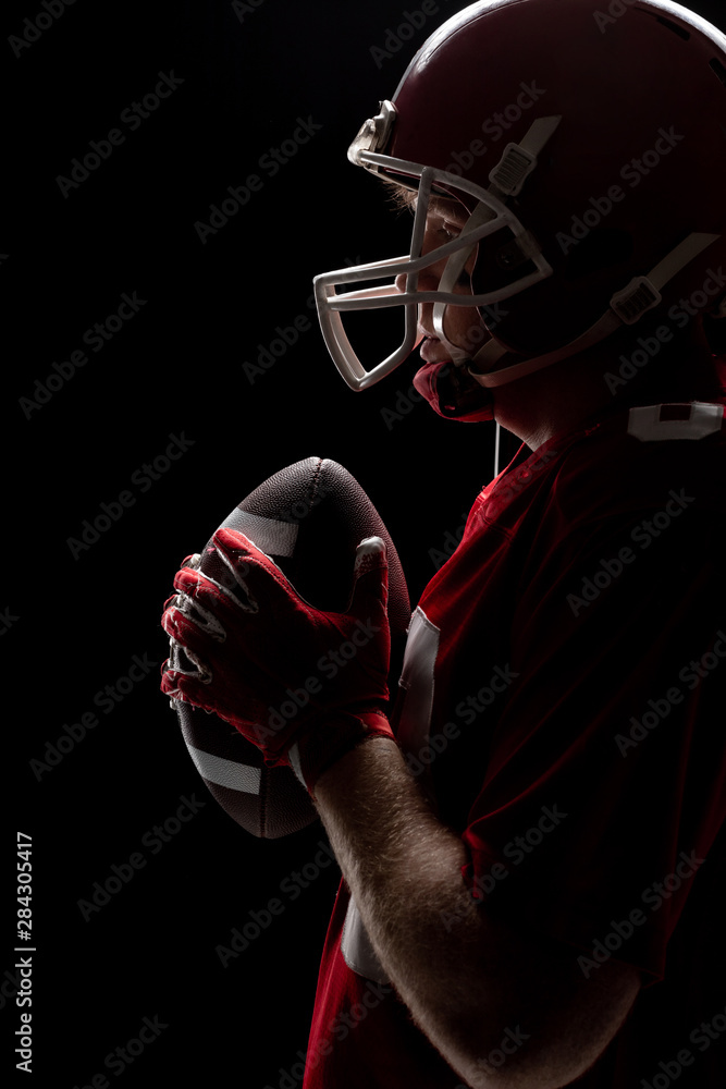 American football player standing with rugby helmet and ball