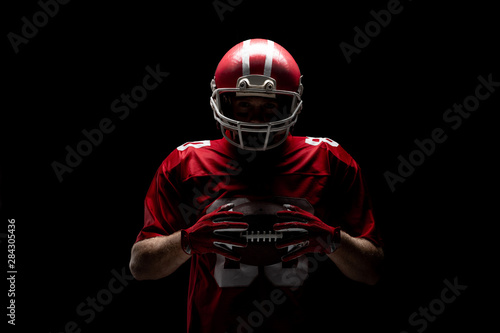 American football player standing with rugby helmet and ball