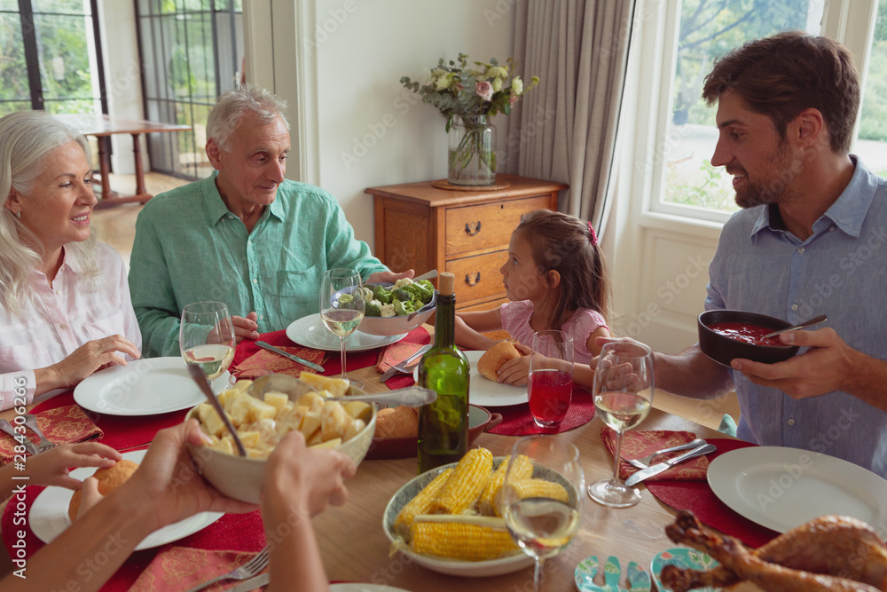 Multi-generation family having food on dining table at home Multi-generation family having food on dining table at home