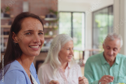 Happy woman looking at camera while having food on dining table