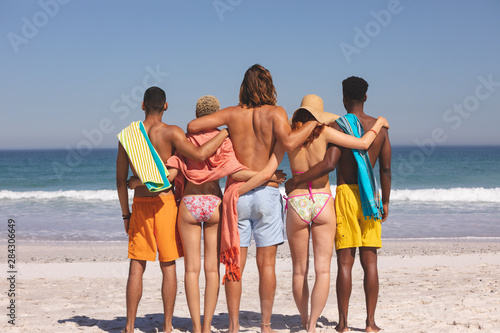 Group of friends standing together on the beach