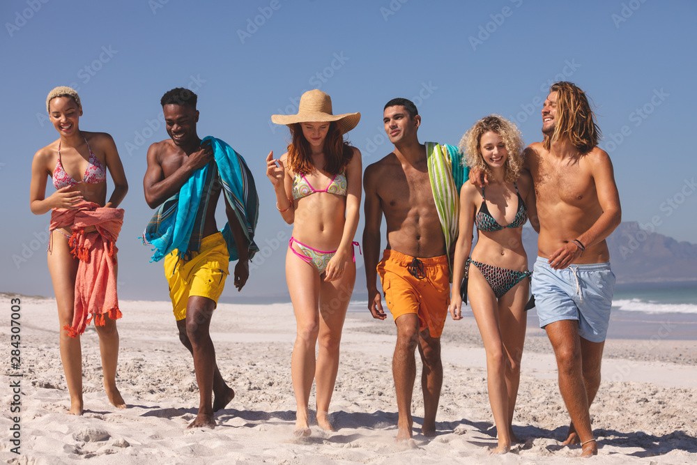 Group of friends walking together on the beach Group of friends walking together on the beach