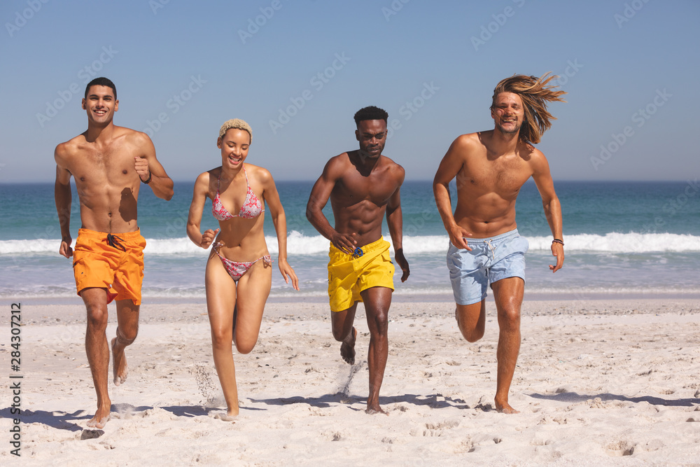 Group of friends running together on the beach Group of friends running together on the beach