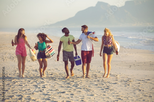 Group of friends walking together on the beach