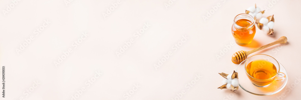 Cup of tea with honey on pastel pink, apricot background Cup of tea with honey on pastel pink, apricot background