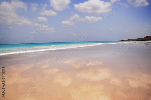  paradise deserted wild beach and clouds reflected in coastal sand.. The coast of the Indian Ocean.