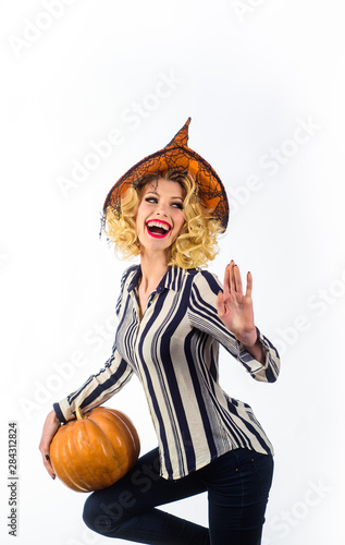 Girl in witch hat. Smiling girl in witch hat with pumpkin. Halloween party. Trick or treating. Preparation Halloween holidays. Happy Halloween. Emotional woman in witch halloween costume. 31 october.