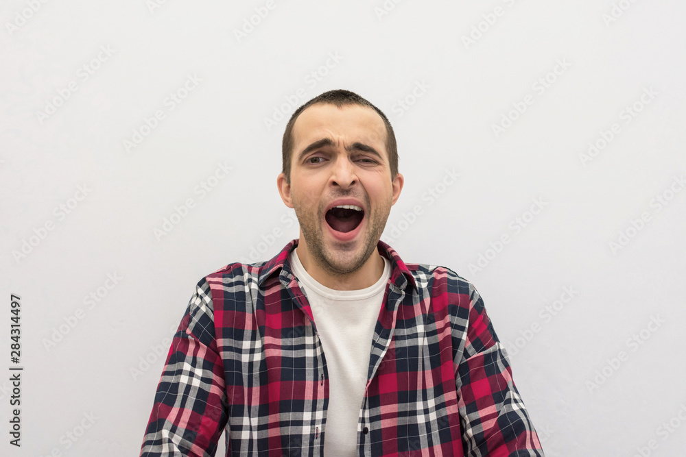 Obraz premium Handsome man yawns, portrait, front view, white background, copy space, advertising