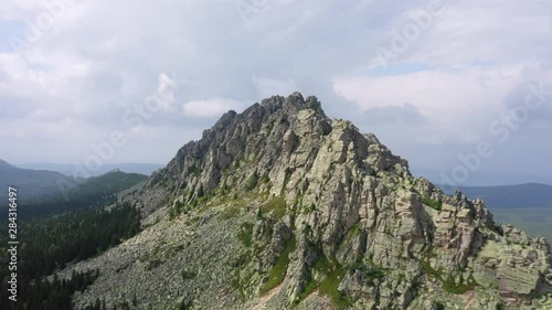 aerial view of ural nature. drone flying over steep stony slope with coniferous, deciduous mixed forest at foot of mountain. natiounal park, ecological protected area in Russia, Otkliknoy greben mount