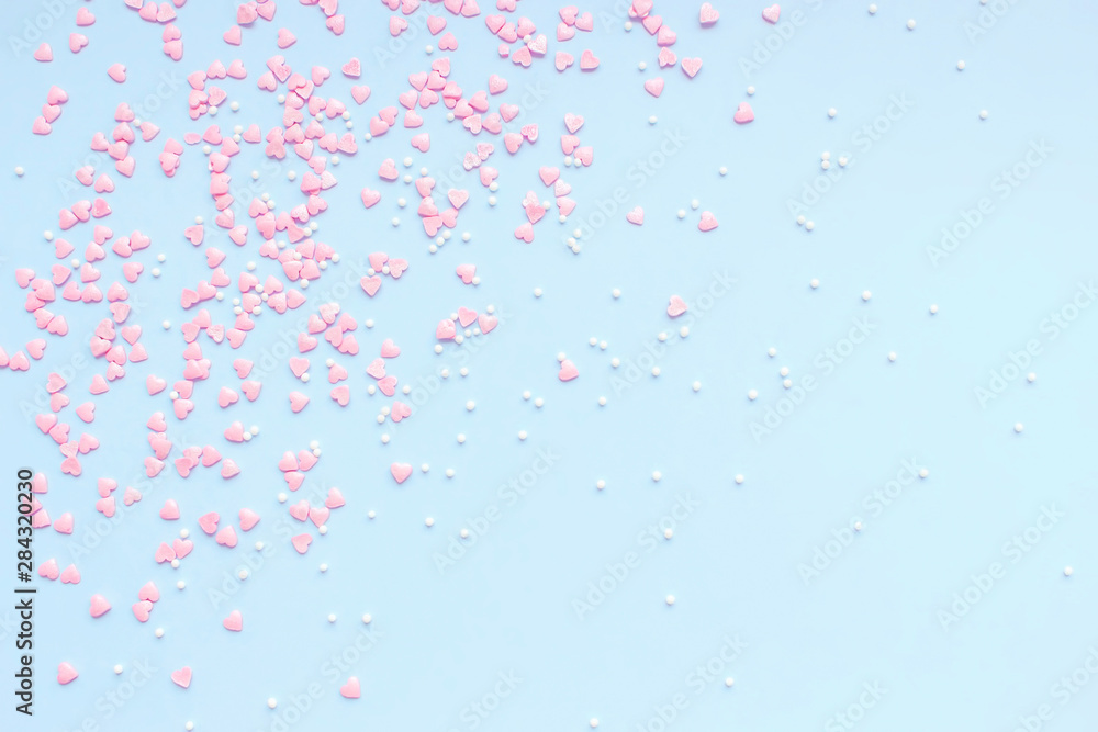 Festive romantic gentle abstract background for the design. Pink confetti in the shape of hearts on a blue background. Top view, flat lay composition. Copy space for text. Festive romantic gentle abstract background for the design. Pink confetti in the shape of hearts on a blue background. Top view, flat lay composition. Copy space for text.