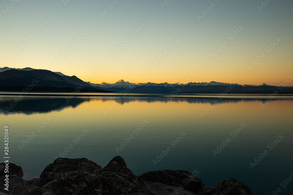 Spectacular panorama scenary of white Mount Cook and clear sky during sunset reflect in Pukaki Lake, South New Zealand.
