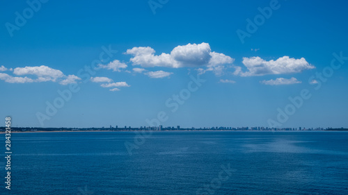 Konstfotografi Dekorative Wolkenbildung über einer fernen Skyline in einer intensiv blauen Umge